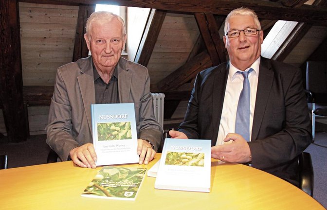 Erwin Gayer (links) und Bürgermeister Peter Schäfer halten die druckfrischen Exemplare des neuen Buchs „Nussdorf – Eine Gölte Wasser“ in den Händen. „Er hat einen wahren Schatz gehoben“, schwärmt Schäfer von dem neuen Werk Gayers.  Foto: Rostek