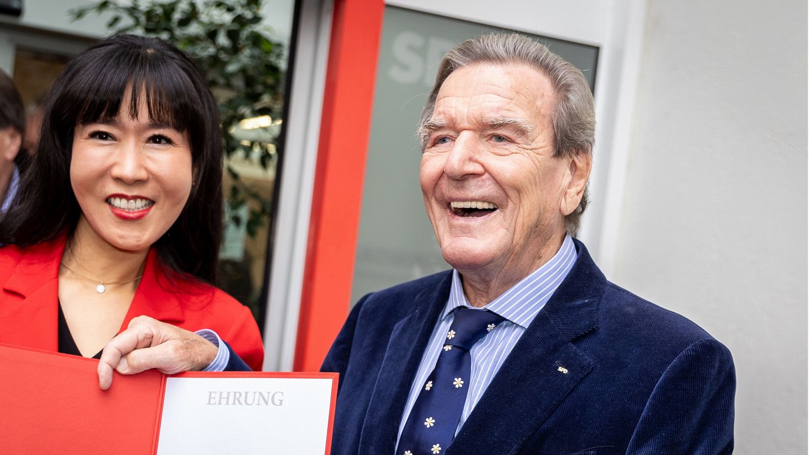 Gerhard Schröder und seine Frau So-yeon Schröder-Kim stehen präsentieren sich nach der Ehrung für den Altkanzler der Öffentlichkeit.Foto: dpa/Moritz Frankenberg