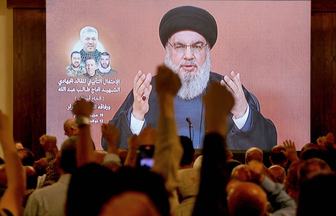 Hisbollah-Anführer Sayyed Hassan Nasrallah bei einer Videoansprache, die von Anhängern in Beirut verfolgt wird<span class='image-autor'>Foto: IMAGO/ZUMA Press Wire/IMAGO/Marwan Naamani</span>