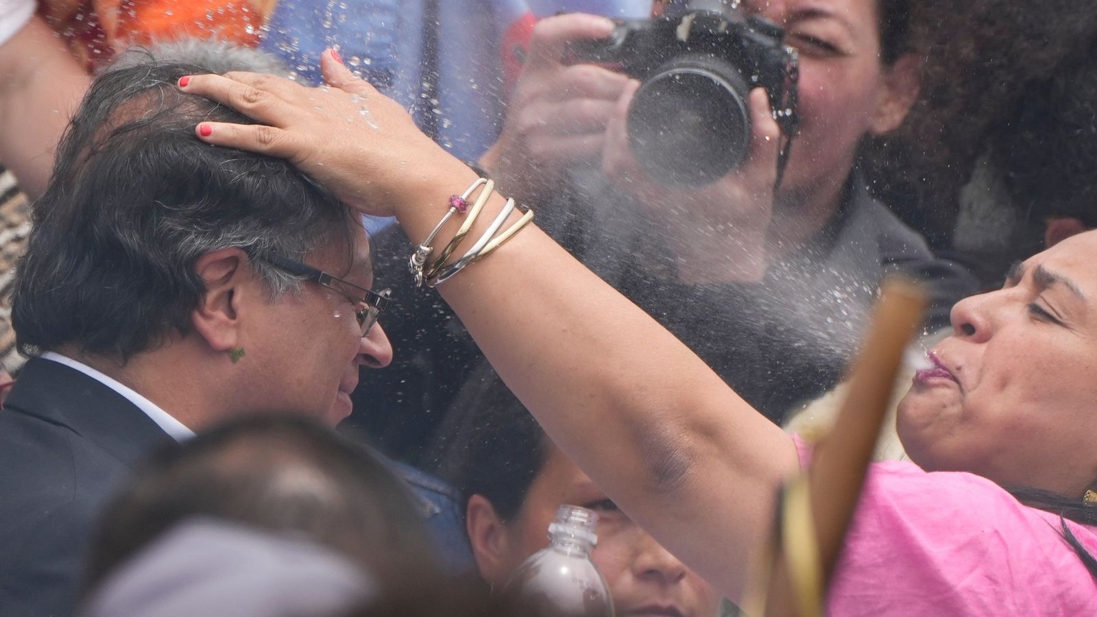 Im Rahmen einer volkstümlichen Amtseinführungszeremonie spritzt eine indigene Frau Wasser über den Kopf des gewählten kolumbianischen Präsidenten Gustavo Petro.Foto: Ariana Cubillos/AP/dpa