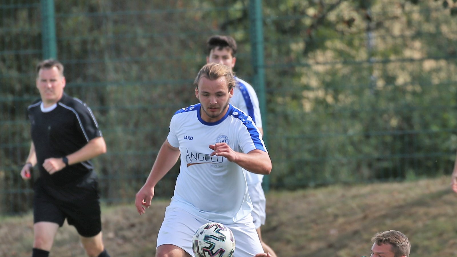 Ilja Bochonow (in Weiß) hat für den SV Illingen den Ball fest im Blick, während sein Iptinger Gegenspieler im Fallen noch alles versucht. Foto: Küppers