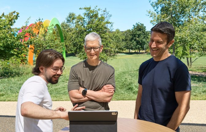 Anton Baranov (l) zeigte seine App sowohl Apple-Chef Tim Cook (M) als auch dessen designiertem Nachfolger John Ternus.<span class='image-autor'>Foto: -/Apple/dpa</span>