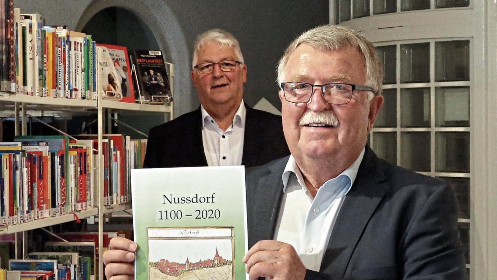 Ernst Kranich (vorne) präsentiert gemeinsam mit Bürgermeister Peter Schäfer das Nussdorfer Heimatbuch. Foto: Küppers Ernst Kranich (vorne) präsentiert gemeinsam mit Bürgermeister Peter Schäfer das Nussdorfer Heimatbuch. Foto: Küppers
