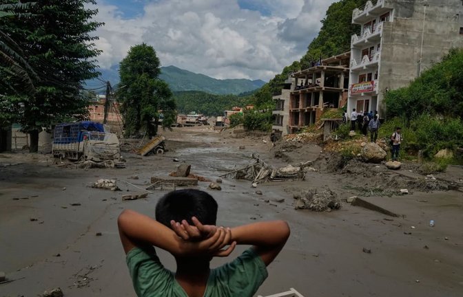 Ein Junge betrachtet die Verwüstungen, die durch Sturzfluten am Fluss Trishuli im nepalesischen Distrikt Nuwakot verursacht wurden. Nach der heftigen Sturzflut in der Grenzregion zwischen China und Nepal gibt es mehrere Tote, nach Behördenangaben werden Hunderte Touristen vermisst.<span class='image-autor'>Niranjan Shrestha/AP/dpa</span>