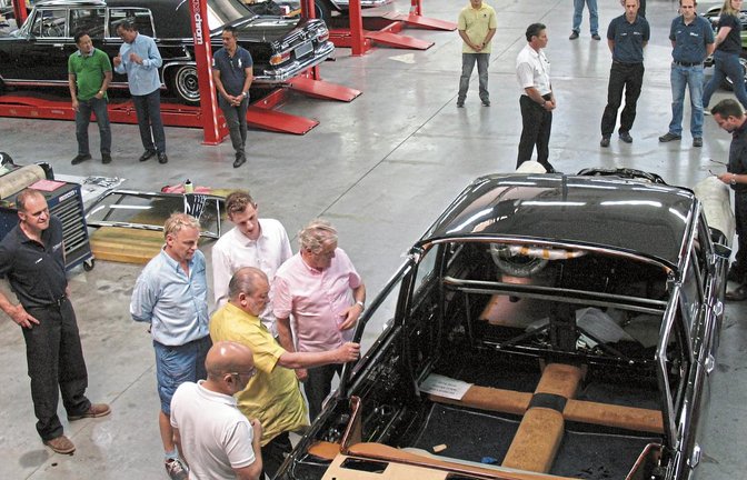 Eigens für die Restaurierung der großen Mercedes-Modelle wie den Typ 600 hat Kienle Automobiltechnik das über 2000 Quadratmeter große Werk II eingerichtet. Der Sultan von Johor (im gelben Hemd) lässt sich von Firmenchef Klaus Kienle (im rosa Hemd) auch die Feinheiten eines der ganz seltenen Mercedes 600 Landaulet erläutern. Fotos: her