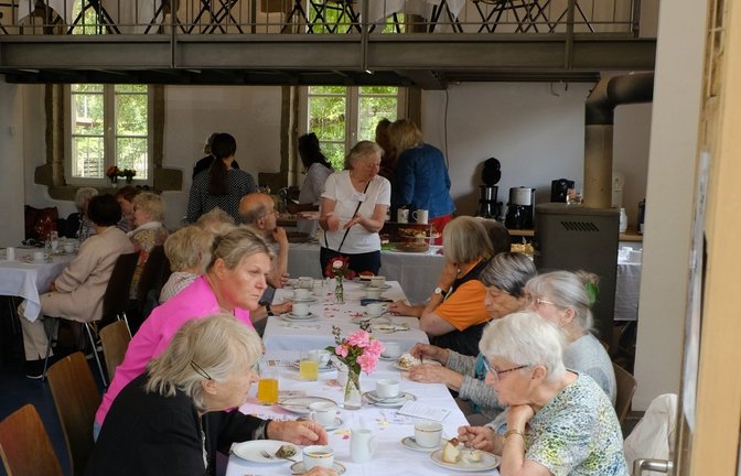 Gäste aus Aurich, Enzweihingen und Riet genießen gemeinsam Kaffee und Kuchen. Manche haben Fragen zum Bürgerbus. Fahrer Helmut Randoll (links im Bild) sichert sich auch noch schnell ein Kuchenstück zwischen zwei Fahrten. <span class='image-autor'>Foto: p</span>