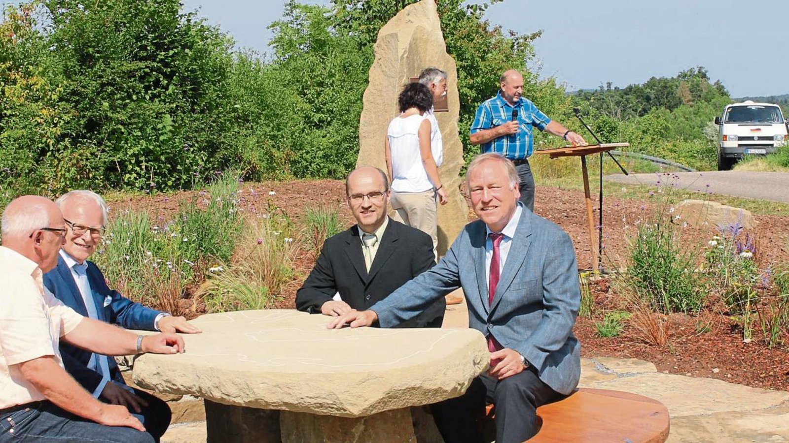Ein Gedenkstein mit Sitzecke entstand neben der Bahntrasse als Erinnerung an die durch die teilweise offene Bauweise des Burgbergtunnels veranlasste Flurneuordnung in Schützingen, von links Manfred Ebser, Vorsitzender der Teilnehmergemeinschaft, Landrat Karl Röckinger, Bürgermeister Harald Eiberger und Ministerialdirigent Hartmut Alker. Foto: Kollros