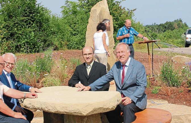Ein Gedenkstein mit Sitzecke entstand neben der Bahntrasse als Erinnerung an die durch die teilweise offene Bauweise des Burgbergtunnels veranlasste Flurneuordnung in Schützingen, von links Manfred Ebser, Vorsitzender der Teilnehmergemeinschaft, Landrat Karl Röckinger, Bürgermeister Harald Eiberger und Ministerialdirigent Hartmut Alker. Foto: Kollros