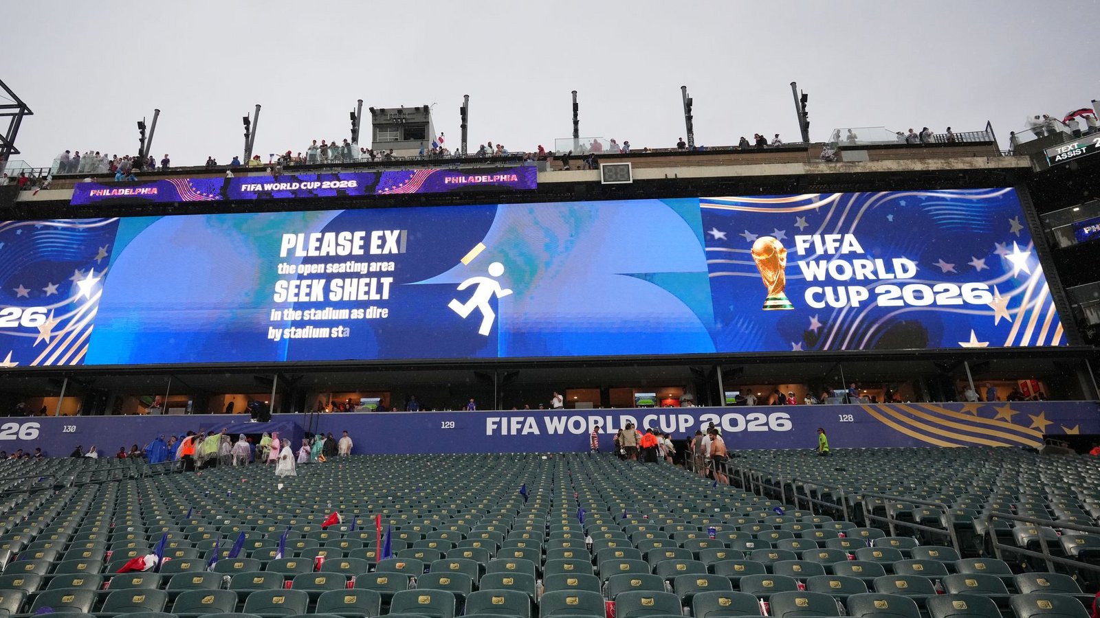 Ein Hinweis auf der Leinwand fordert die Fans auf, ihre Plätze zu verlassen.Foto: Petr David Josek/AP/dpa