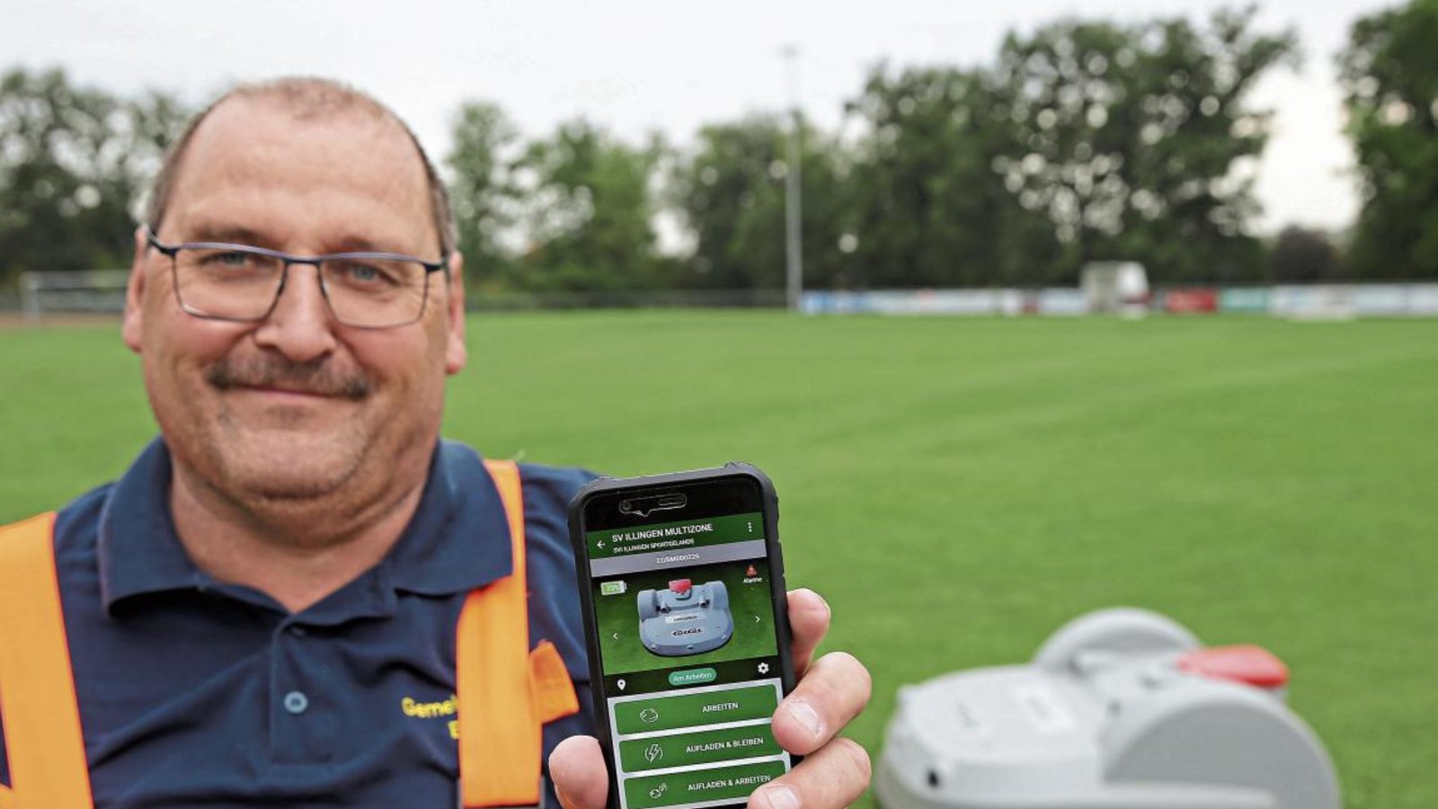 Illingens Bauhofleiter Hanspeter Schmidt kann den Rasenmähroboter mobil per App steuern. Foto: Küppers Illingens Bauhofleiter Hanspeter Schmidt kann den Rasenmähroboter mobil per App steuern. Foto: Küppers