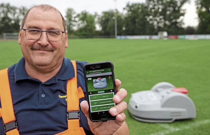 Illingens Bauhofleiter Hanspeter Schmidt kann den Rasenmähroboter mobil per App steuern. Foto: Küppers