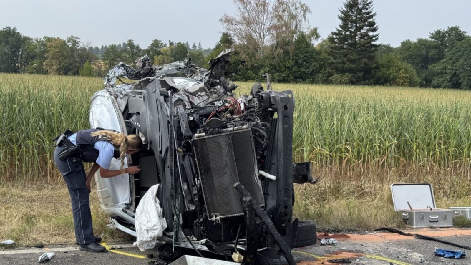 Eine Polizistin inspiziert den völlig zerstörten Kleintransporter. Aus unbekannter Ursache war das Fahrzeug am Freitagnachmittag auf der B297 in den Gegenverkehr geraten und frontal mit einem Bus kollidiert. Der Fahrer des Transporters starb noch an der Unfallstelle, mehrere Menschen wurden teils schwer verletzt.SDMG / Schulz Eine Polizistin inspiziert den völlig zerstörten Kleintransporter. Aus unbekannter Ursache war das Fahrzeug am Freitagnachmittag auf der B297 in den Gegenverkehr geraten und frontal mit einem Bus kollidiert. Der Fahrer des Transporters starb noch an der Unfallstelle, mehrere Menschen wurden teils schwer verletzt.SDMG / Schulz