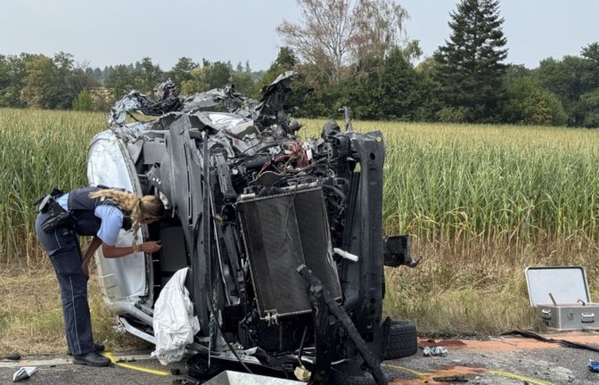 Eine Polizistin inspiziert den völlig zerstörten Kleintransporter. Aus unbekannter Ursache war das Fahrzeug am Freitagnachmittag auf der B297 in den Gegenverkehr geraten und frontal mit einem Bus kollidiert. Der Fahrer des Transporters starb noch an der Unfallstelle, mehrere Menschen wurden teils schwer verletzt.<span class='image-autor'>SDMG / Schulz</span>