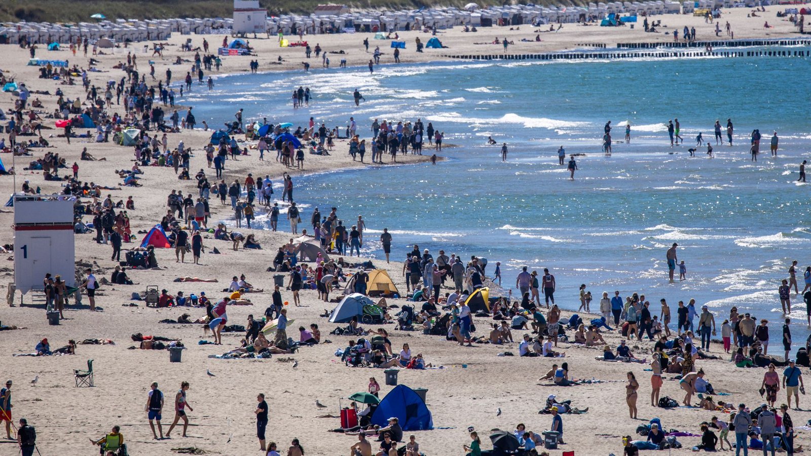 Badegäste nutzen am 12. Mai 2024 das sonnige warme Wetter zu einem Strandbesuch an der Ostseeküste in Warnemünde.Doch im Wasser des Binnenmeeres lauert eine unsichtbare, tödliche Gefahr: Thallium.Foto: dpa/Jens Büttner Badegäste nutzen am 12. Mai 2024 das sonnige warme Wetter zu einem Strandbesuch an der Ostseeküste in Warnemünde.Doch im Wasser des Binnenmeeres lauert eine unsichtbare, tödliche Gefahr: Thallium.Foto: dpa/Jens Büttner