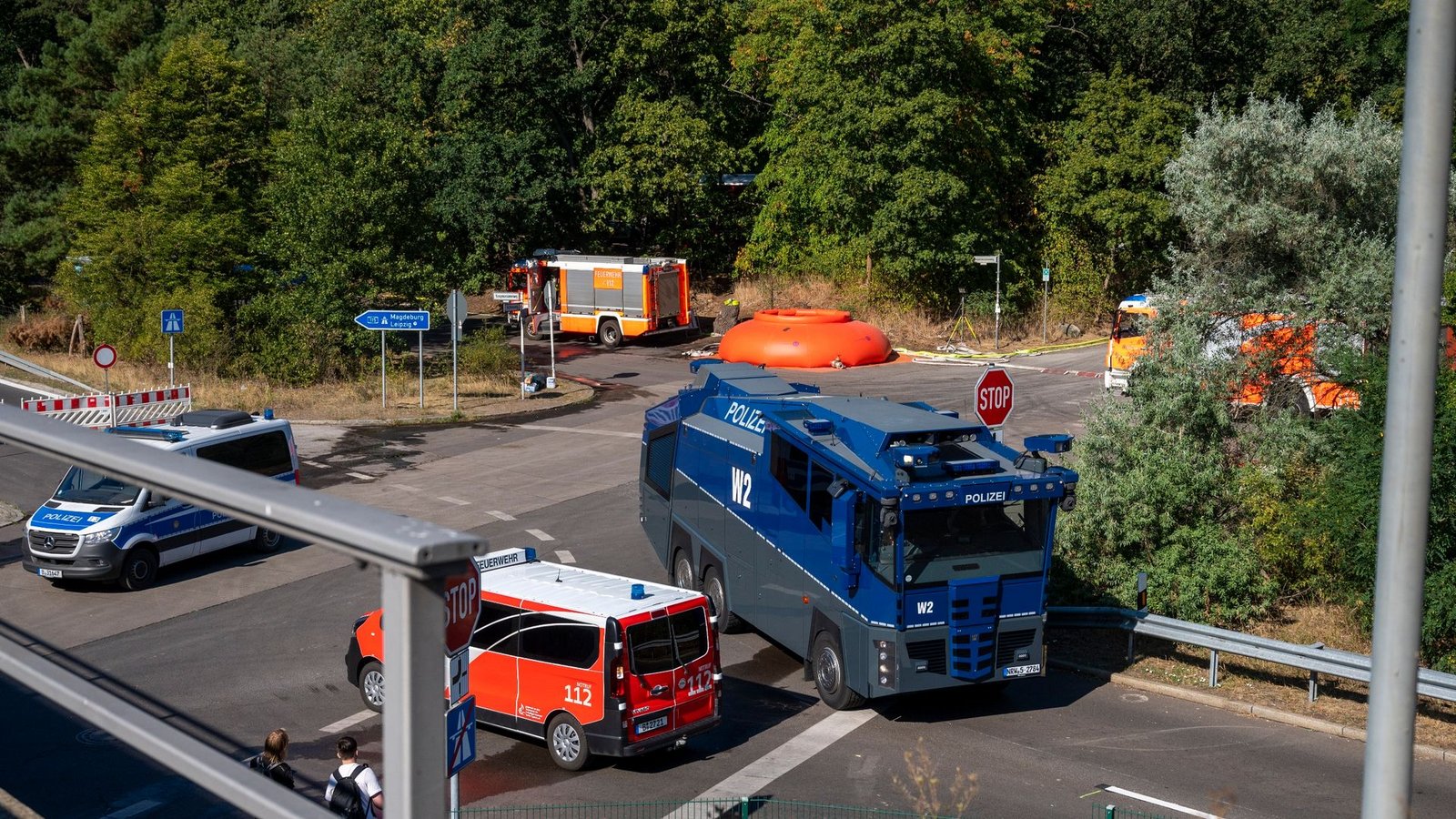 Feuerwehrautos und Fahrzeuge der Polizei stehen in der Nähe der Brandstelle im Grunewald.Foto: Christophe Gateau/dpa