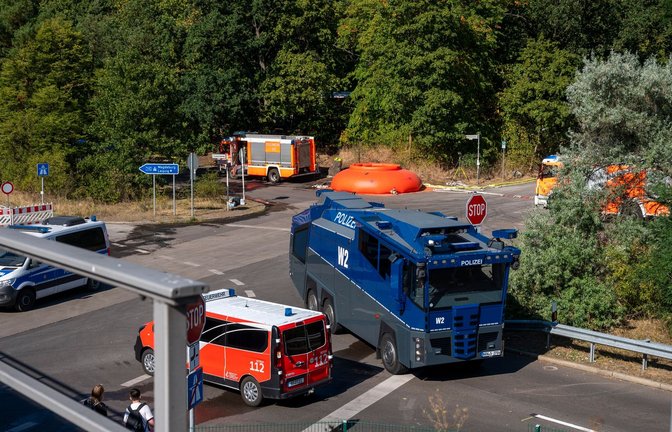 Feuerwehrautos und Fahrzeuge der Polizei stehen in der Nähe der Brandstelle im Grunewald.<span class='image-autor'>Foto: Christophe Gateau/dpa</span>