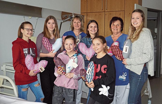 Lara Mühlfelder, Marie Prella, Selina Schneeweis, Schwester Monika, Jasmin Schneeweis, Lilly Prella, Schwester Sylvia und Isabelle Bleicher (von links) bei der Übergabe der Herzkissen an die Station 3 B des Krankenhauses Bietigheim.  Foto: p