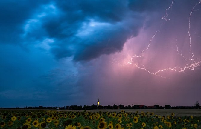 Blitze zucken am Abend über Wechmar mit der Dorfkirche Sankt Viti (Mi.) während Gewitter über Teile von Thüringen ziehen (Archivfoto).<span class='image-autor'>Imago/Funke Foto Services</span>
