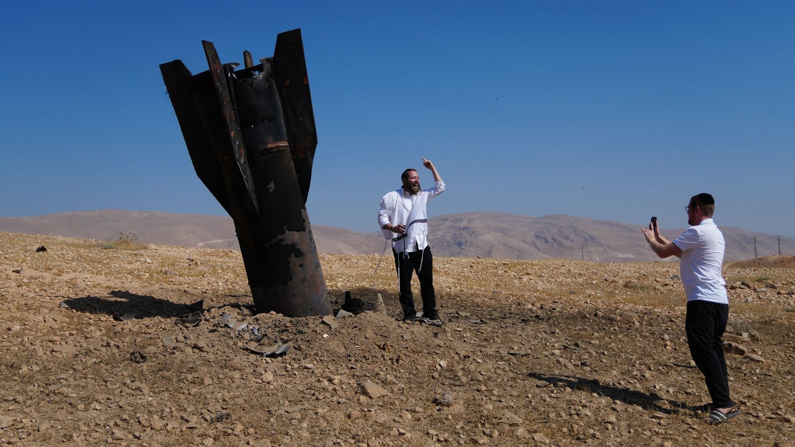 Menschen neben dem Wrack einer iranischen Rakete, die im Westjordanland eingeschlagen ist.Foto: Mahmoud Illean/AP/dpa