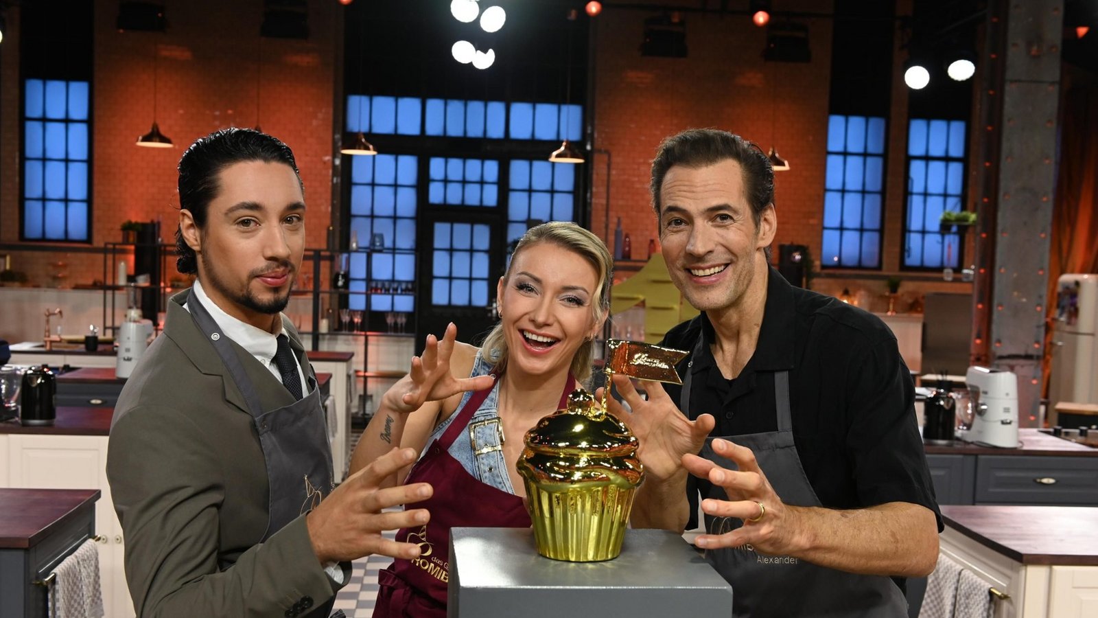 (v.l.n.r.) René Casselly, Anna-Carina Woitschack und Alexander Mazza kämpfen um den goldenen Cupcake.Foto: Joyn / André Kowalski (v.l.n.r.) René Casselly, Anna-Carina Woitschack und Alexander Mazza kämpfen um den goldenen Cupcake.Foto: Joyn / André Kowalski
