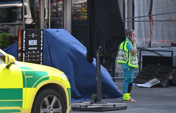 Eine Rettungskraft steht vor dem OXY-Gebäude am Place De Brouckere. Bei einem Gebäudebrand sind nach übereinstimmenden Medienberichten mehrere Menschen gestorben. (zu dpa: «Drama auf Baustelle in Brüssel - Fünf Tote in Aufzug»)<span class='image-autor'>Emile Windal/Belga/dpa</span>