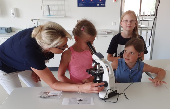 Lehrerin Jasmin Klein zeigt im Naturwissenschaftsraum den kleinen Besuchern des Schulfests der Gemeinschaftsschule Sachsenheim, wie ein Mikroskop richtig bedient wird.  <span class='image-autor'>Foto: Glemser</span>