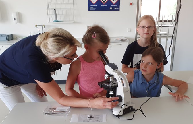 Lehrerin Jasmin Klein zeigt im Naturwissenschaftsraum den kleinen Besuchern des Schulfests der Gemeinschaftsschule Sachsenheim, wie ein Mikroskop richtig bedient wird.  <span class='image-autor'>Foto: Glemser</span>