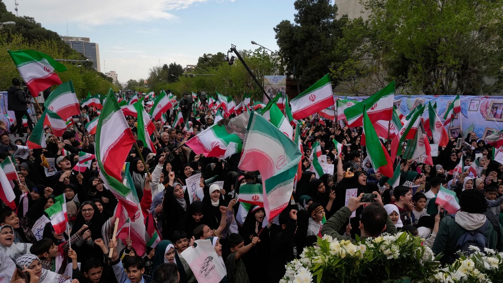 Menschen schwenken iranische Fahnen bei einer Gedenkfeier für Schulkinder, die am 28. Februar bei einem US-Luftangriff auf eine Schule in Minab getötet wurden.Foto: Vahid Salemi/AP/dpa/Vahid Salemi Menschen schwenken iranische Fahnen bei einer Gedenkfeier für Schulkinder, die am 28. Februar bei einem US-Luftangriff auf eine Schule in Minab getötet wurden.Foto: Vahid Salemi/AP/dpa/Vahid Salemi
