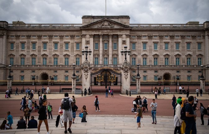 Touristen stehen vor den Toren vom Buckingham Palast in London.<span class='image-autor'>Foto: Aaron Chown/PA Archive/dpa</span>