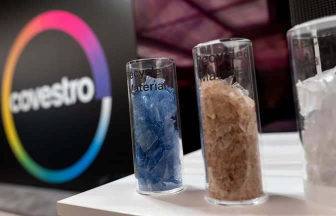 Eine deutsche Firma wird arabisch: Das Logo des Spezialchemie-Konzerns in einem Firmen-Showroom, davor Gläser mit Covestro-Materialien.<span class='image-autor'>Foto: Fabian Strauch/dpa</span>