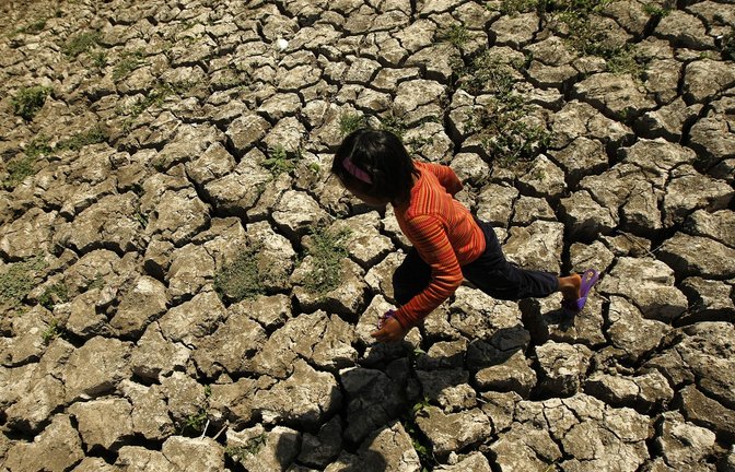 Ein philippinisches Kind läuft in der Provinz Cavite auf den Philippinen in einem ausgetrockneten Bewässerungskanal spazieren, der durch das Wetterphänomen El Niño ausgetrocknet ist.<span class='image-autor'>Foto: EPA/dpa/Francis R. Malasig</span>
