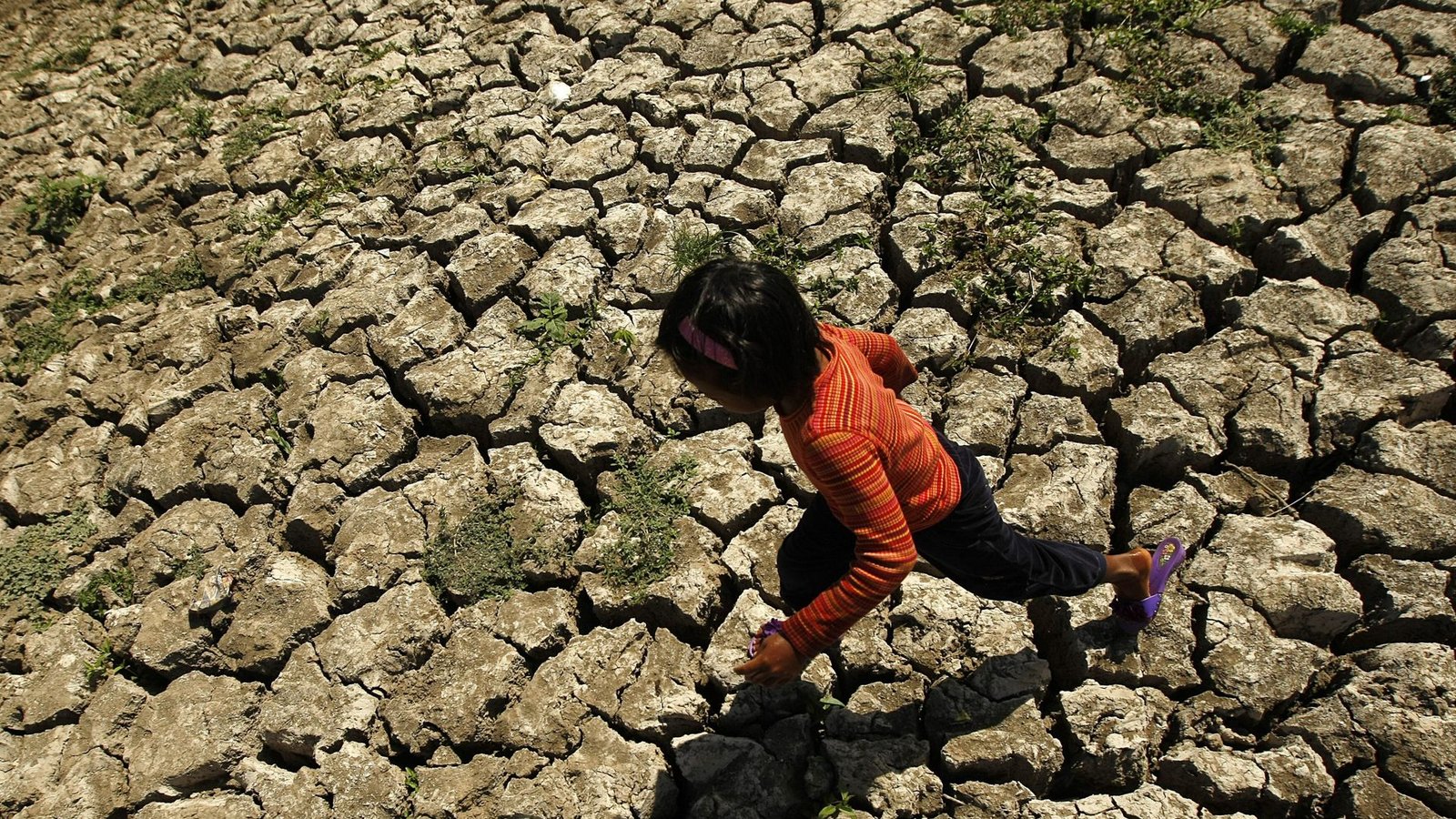 Ein philippinisches Kind läuft in der Provinz Cavite auf den Philippinen in einem ausgetrockneten Bewässerungskanal spazieren, der durch das Wetterphänomen El Niño ausgetrocknet ist.Foto: EPA/dpa/Francis R. Malasig Ein philippinisches Kind läuft in der Provinz Cavite auf den Philippinen in einem ausgetrockneten Bewässerungskanal spazieren, der durch das Wetterphänomen El Niño ausgetrocknet ist.Foto: EPA/dpa/Francis R. Malasig