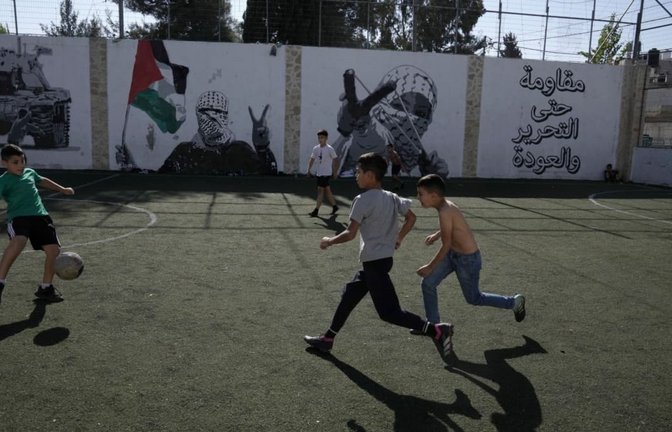 Palästinensische Kinder spielen Fußball im Aida Flüchtlingslager in Bethlehem im Westjordanland. Ein 17-jähriger Fußballer ist nach einem Angriff israelischer Siedler im Westjordanland verstorben (Archivfoto).<span class='image-autor'>Mahmoud Illean/AP/dpa</span>