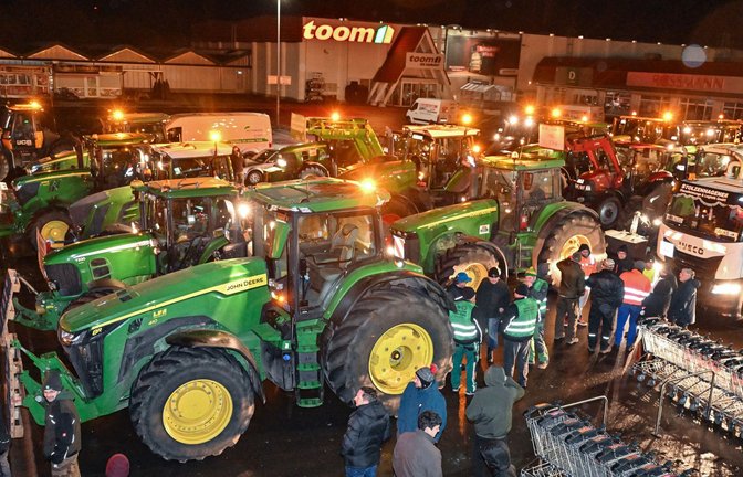 Die Bilder ähneln sich überall in Deutschland: Landwirte haben sich auf einem Parkplatz versammelt, um gegen die Beschlüsse der Bundesregierung zu demonstrieren.<span class='image-autor'>Foto: dpa/Patrick Pleul</span>