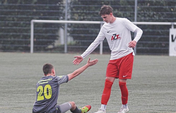 Jonas Neuffer (von links) von der SGM Hohenhaslach/Freudental ist nach dem Abpfiff am Boden zerstört. Enttäuscht hat er sich auf den Rasen sinken lassen – kurz bevor sich Nussdorfs David Grözinger verabschiedet. Foto: Nachreiner