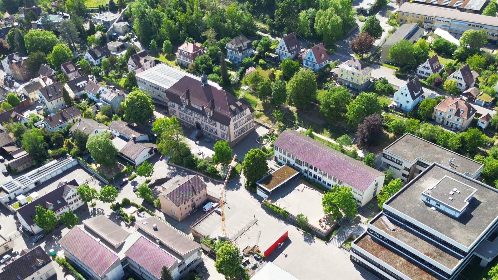 Die Parkplätze im Schulhof von Schlossbergschule und Ferdinand-Steinbeis-Realschule in der Bildmitte fallen weg. Dort werden Containerklassenzimmer aufgestellt. Über die Frage, wo die Lehrkräfte künftig parken sollen, wird im Gemeinderat kontrovers diskutiert.  Foto: Küppers