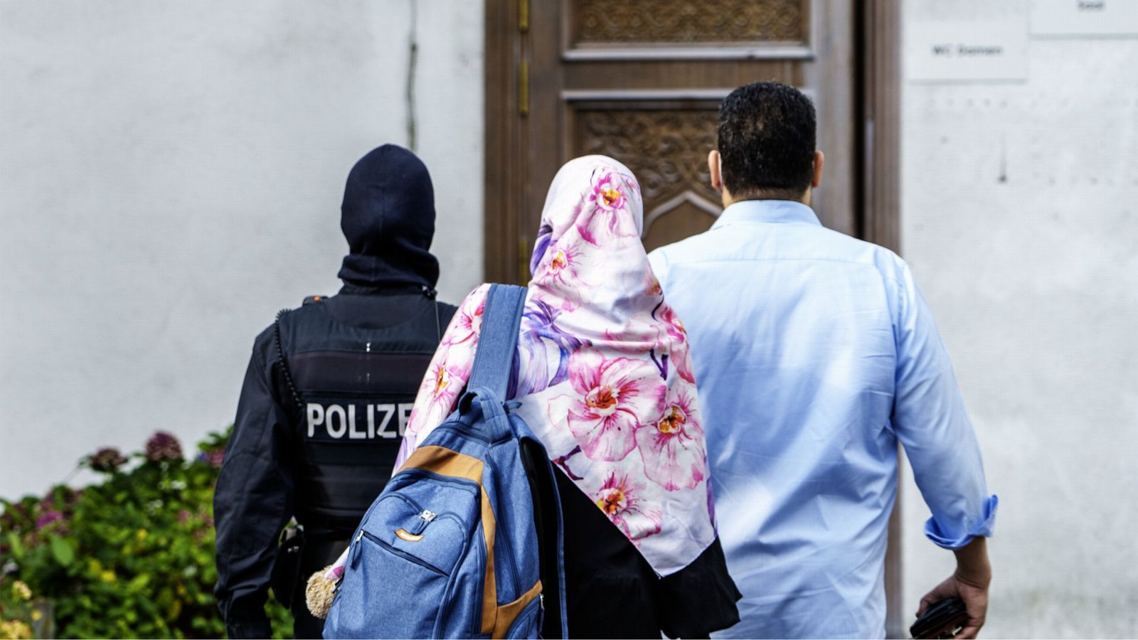 Ein Polizist begleitet zwei Personen während einer Razzia auf das Gelände vom Islamischen Zentrum Hamburg (IZH).Foto: dpa/Andreas Arnold Ein Polizist begleitet zwei Personen während einer Razzia auf das Gelände vom Islamischen Zentrum Hamburg (IZH).Foto: dpa/Andreas Arnold