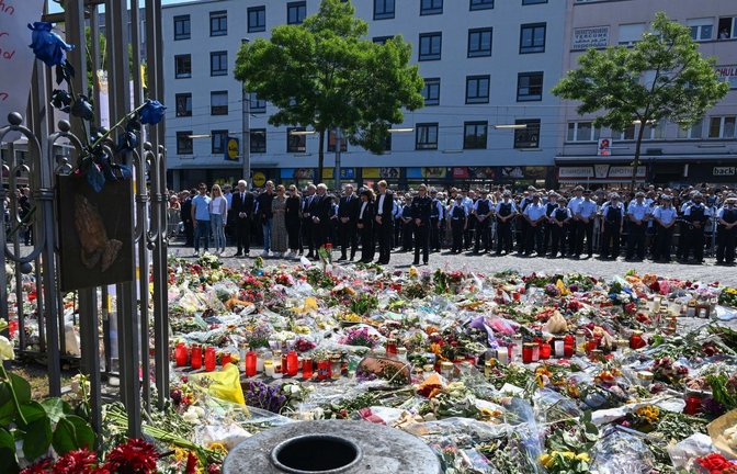 Gedenkfeier für Rouven Laur auf dem Mannheimer Marktplatz. Von den beiden Bäumen, unter denen die Polizisten stehen, lief am Tattag Youssuf Hanash los, um sich dem Attentäter entgegenzustellen und zu helfen.<span class='image-autor'>Foto: dpa/Bernd Weißbrod</span>
