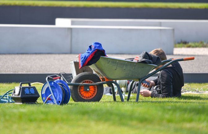 Ein Arbeiter macht auf dem Gelände der Landesgartenschau in Landau in der Pfalz neben einer Schubkarre eine Pause.<span class='image-autor'>Foto: Uwe Anspach/dpa/Uwe Anspach</span>