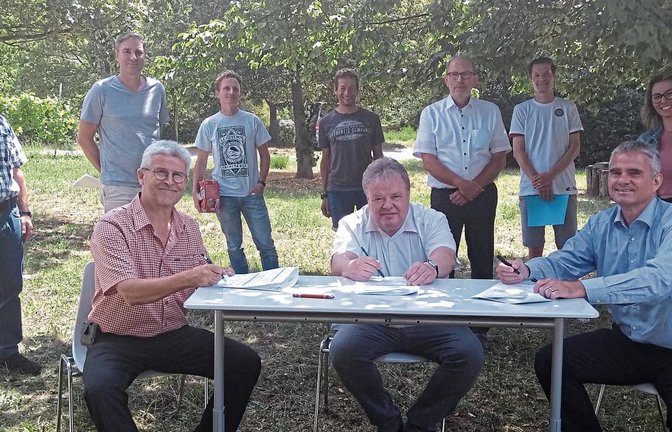 Im Garten der Kirbachschule in Hohenhaslach unterzeichneten Schulleiter Rainer Graef (links), der Personalleiter der Bodensee-Wasserversorgung Ingo Kröhnert (Mitte) und Bürgermeister Holger Albrich (rechts) die Urkunden für die neue Bildungspartnerschaft vor den Augen der begeisterten Lehrerschaft und Vertretern der IHK.  Foto: Glemser