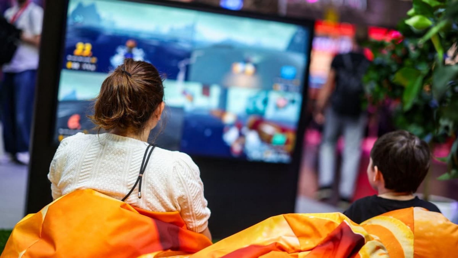 Zwei Besucher der Messe Gamescom sitzen auf Sitzsäcken vor einem Bildschirm und spielen ein Videospiel. Künstliche Intelligenz verändert das Spielen.Christoph Reichwein/dpa Zwei Besucher der Messe Gamescom sitzen auf Sitzsäcken vor einem Bildschirm und spielen ein Videospiel. Künstliche Intelligenz verändert das Spielen.Christoph Reichwein/dpa