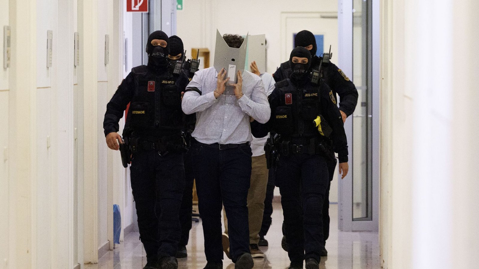 Der Angeklagte im Prozess um mutmaßliche Anschlagspläne auf das Wiener Taylor-Swift-Konzert wird von Polizei im Gericht begleitet.Foto: Tobias Steinmaurer/APA/dpa/Tobias Steinmaurer