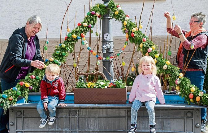 Suse Herrmann (links) mit Enkeln und Petra Pfeiffer behängten den Hohenhaslacher Brunnen mit Eiern. Foto: Pangerl