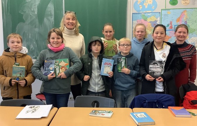 Louis Ulmer aus der Klasse 6c hat den Vorlesewettbewerb der Ferdinand-Steinbeis-Realschule gewonnen. Er wird seine Schule damit 2025 beim Kreisentscheid in Ludwigsburg vertreten. Die Jury der Ferdinand-Steinbeis-Realschule – Schulleitung Claudia Süß-Räuchle, Elternbeirätin Simone Schauer und Siebtklässlerin Meike Wagner – musste zuvor aus sechs Klassensiegern den Besten oder die Beste auswählen. Zuerst durfte jeder drei Minuten aus seinem vorbereiteten Text vortragen. Von der „Schule der magischen Tiere“ bis zu „Gregs Tagebuch“ war alles dabei und die einzelnen Klassen zeigten mit großem Applaus die Unterstützung für ihre Klassensieger. Im zweiten Teil des Wettbewerbs las jeder noch einen Fremdtext. Nach einer Jury-Beratung war klar: Louis Ulmer ist der Schulsieger. Auf dem Bild (vorne, von links): Maxim Bischof (6b), Sophie Schuler (6b), Louis Ulmer (6c), Tim König (6a), Nisa Nalci (6c); hinten: Claudia Süß-Räuchle, Marie Zabel (6a) sowie die Jurymitglieder Meike Wagner und Simone Schauer.  <span class='image-autor'>Foto: p</span>