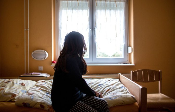 Eine Frau sitzt in einem Frauenhaus auf einem Bett. In Deutschland fehlen über 13.000 Frauenhausplätze (Symbolfoto).<span class='image-autor'>Foto: picture alliance/dpa/Maja Hitij</span>