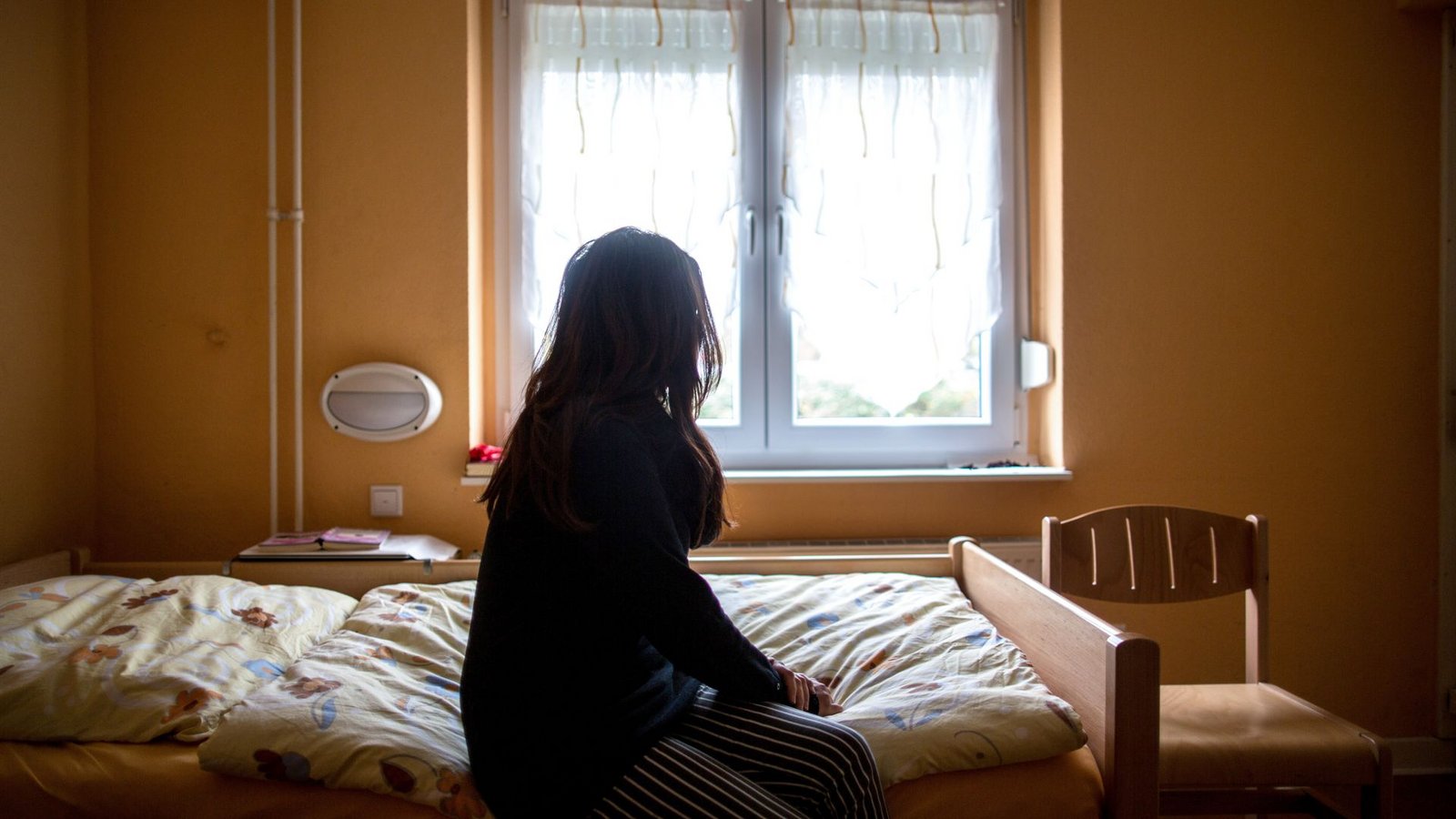 Eine Frau sitzt in einem Frauenhaus auf einem Bett. In Deutschland fehlen über 13.000 Frauenhausplätze (Symbolfoto).Foto: picture alliance/dpa/Maja Hitij Eine Frau sitzt in einem Frauenhaus auf einem Bett. In Deutschland fehlen über 13.000 Frauenhausplätze (Symbolfoto).Foto: picture alliance/dpa/Maja Hitij
