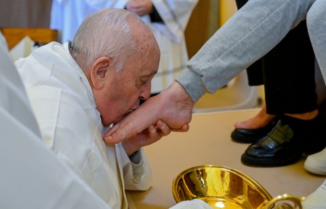 Papst Franziskus küsst den Fuß von einer weiblichen Insassin des Rebibbia-Gefängnisses.<span class='image-autor'>Foto: Vatican Media/AP/dpa</span>