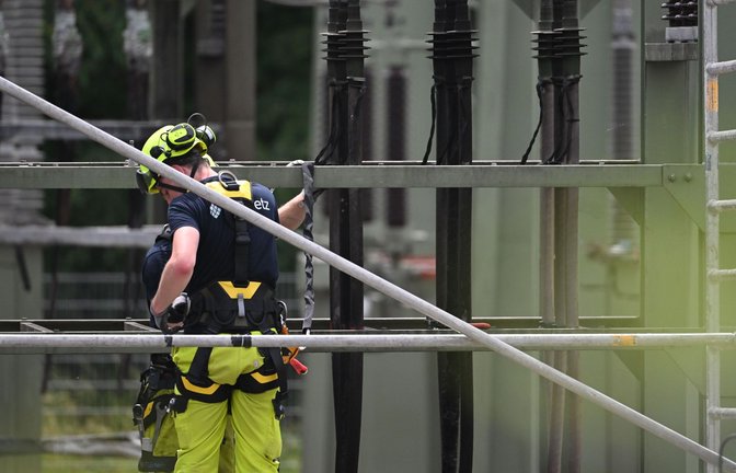 Ein Mitarbeiter von FairNetz arbeitet auf dem Gelände eines Umspannwerks, in dem es in der Nacht gebrannt hatte.<span class='image-autor'>Foto: Marijan Murat/dpa/Marijan Murat</span>