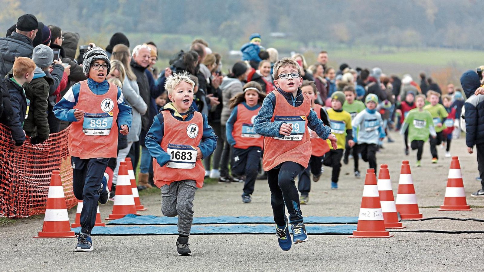 Hunderte Zuschauer säumen die Strecke vor allem im Zieleinlauf, wenn beim Nussdorflauf die jüngsten Athleten auf die Strecke gehen – hier haben es die Schüler der Altersklasse U 8 fast geschafft. Fotos: Küppers Hunderte Zuschauer säumen die Strecke vor allem im Zieleinlauf, wenn beim Nussdorflauf die jüngsten Athleten auf die Strecke gehen – hier haben es die Schüler der Altersklasse U 8 fast geschafft. Fotos: Küppers
