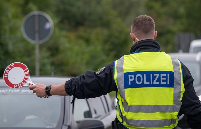 Ein Polizist hält Fahrzeuge an der Grenze zu Deutschland an.<span class='image-autor'>Foto: dpa/Harald Tittel</span>